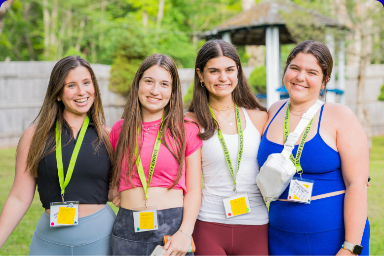 A diverse group of young adults jumping with excitement in a lush green garden during a community event.
