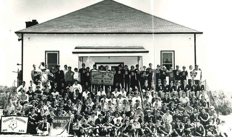 A diverse crowd of people celebrating at a concert, raising their hands and cheering.